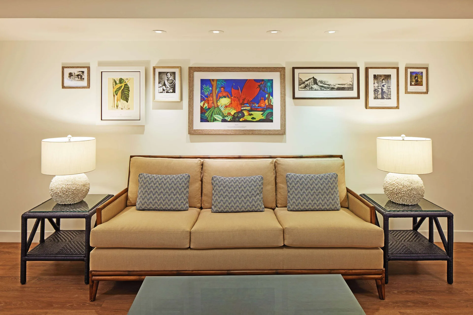 Lobby seating with a tan sofa and framed art at OUTRIGGER Reef Waikiki Beach Resort.