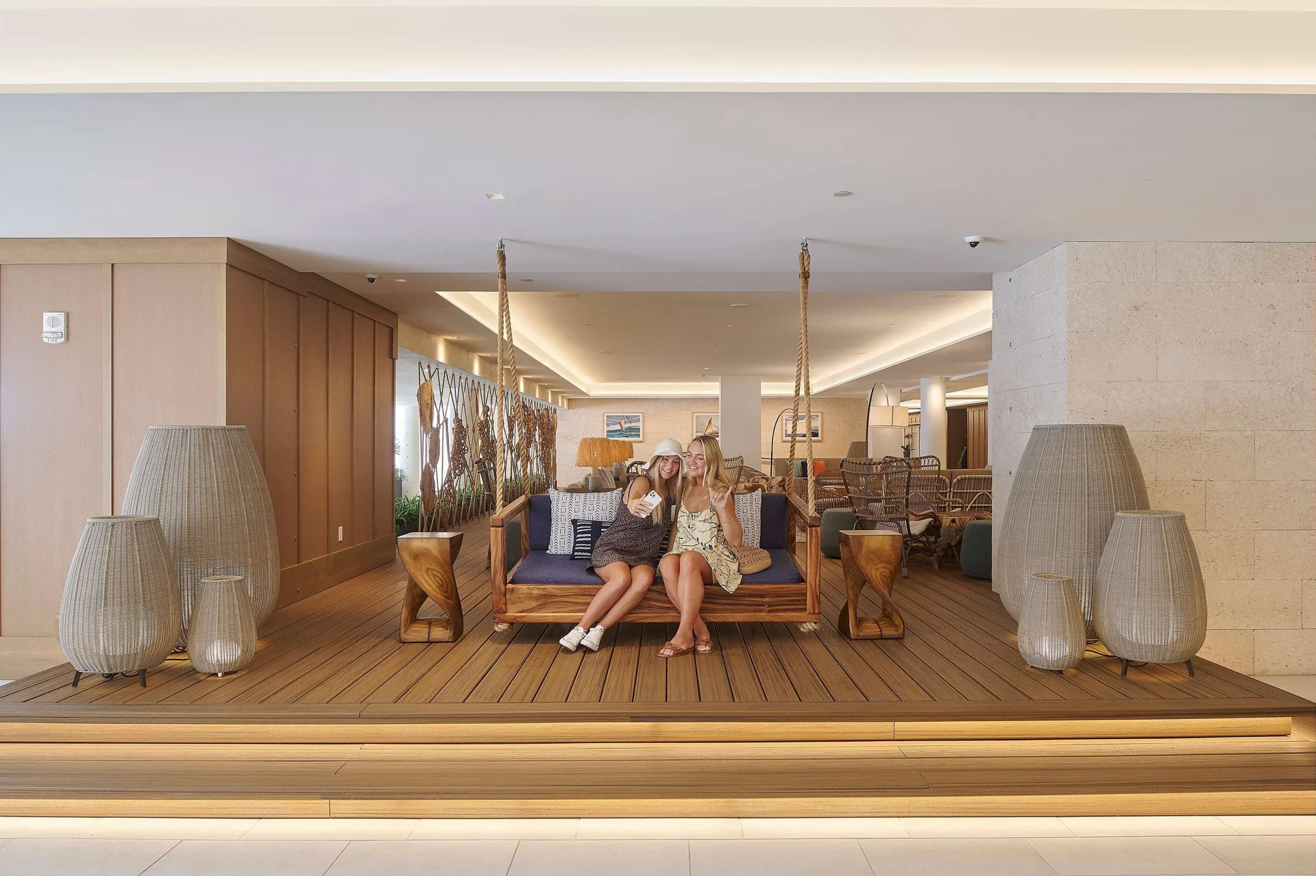 Lobby swing seating with two guests at OUTRIGGER Reef Waikiki Beach Resort.