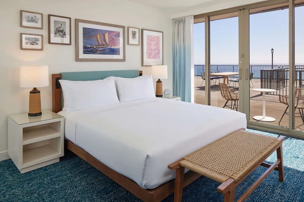 King guest room with terrace and ocean beyond at OUTRIGGER Reef Waikiki Beach Resort.