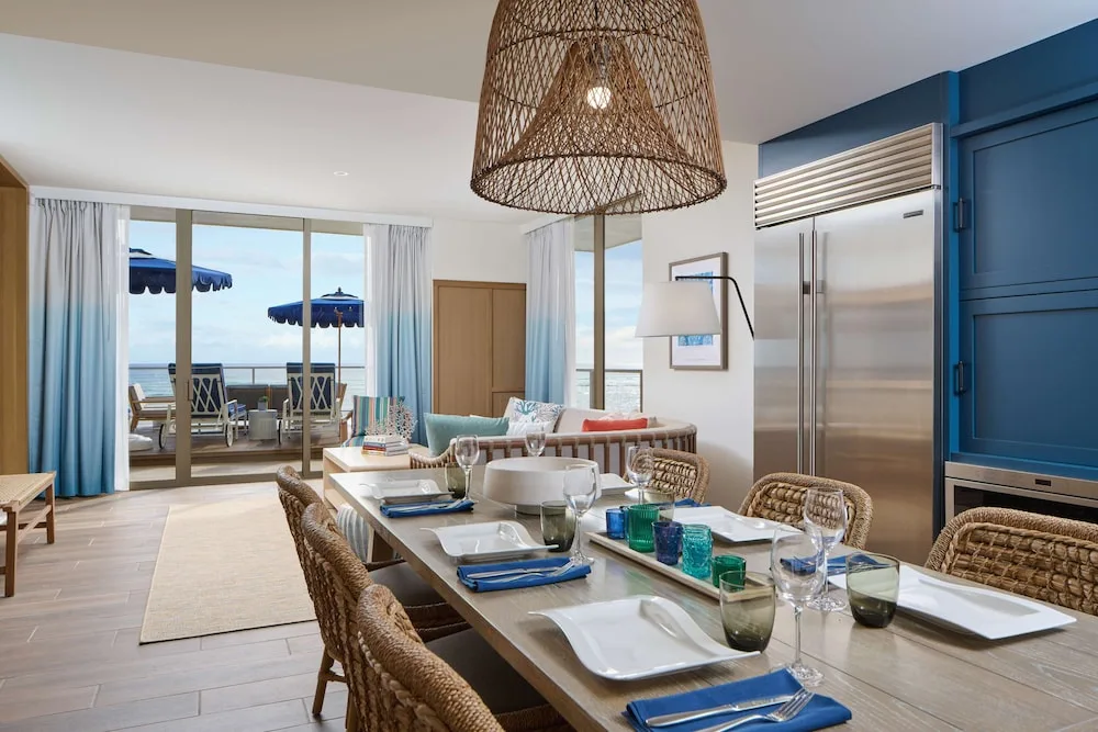 Dining table and kitchen beside an oceanfront terrace at OUTRIGGER Reef Waikiki Beach Resort.