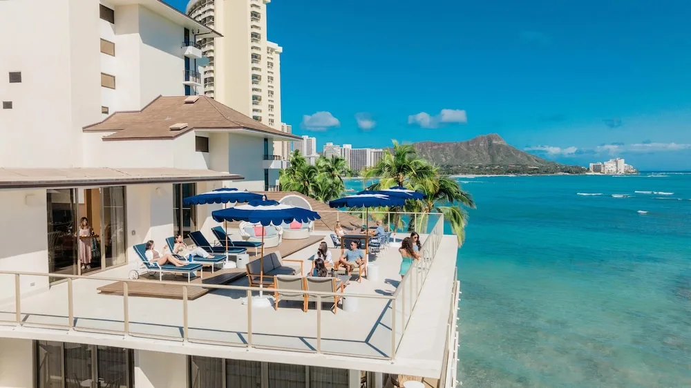 Oceanfront terrace with loungers and Diamond Head view at OUTRIGGER Reef Waikiki Beach Resort.