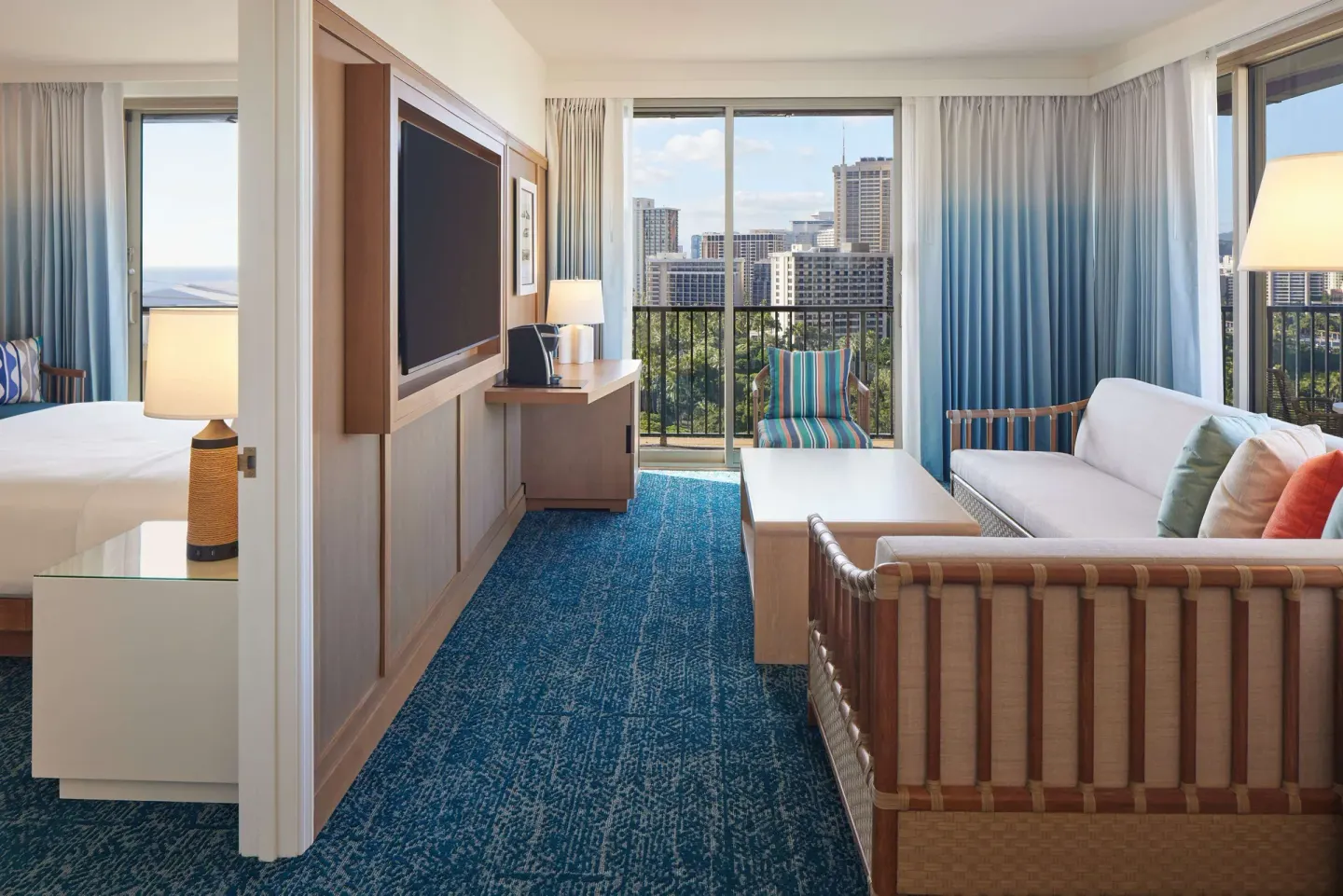 Suite living area with balcony and city view at OUTRIGGER Reef Waikiki Beach Resort.