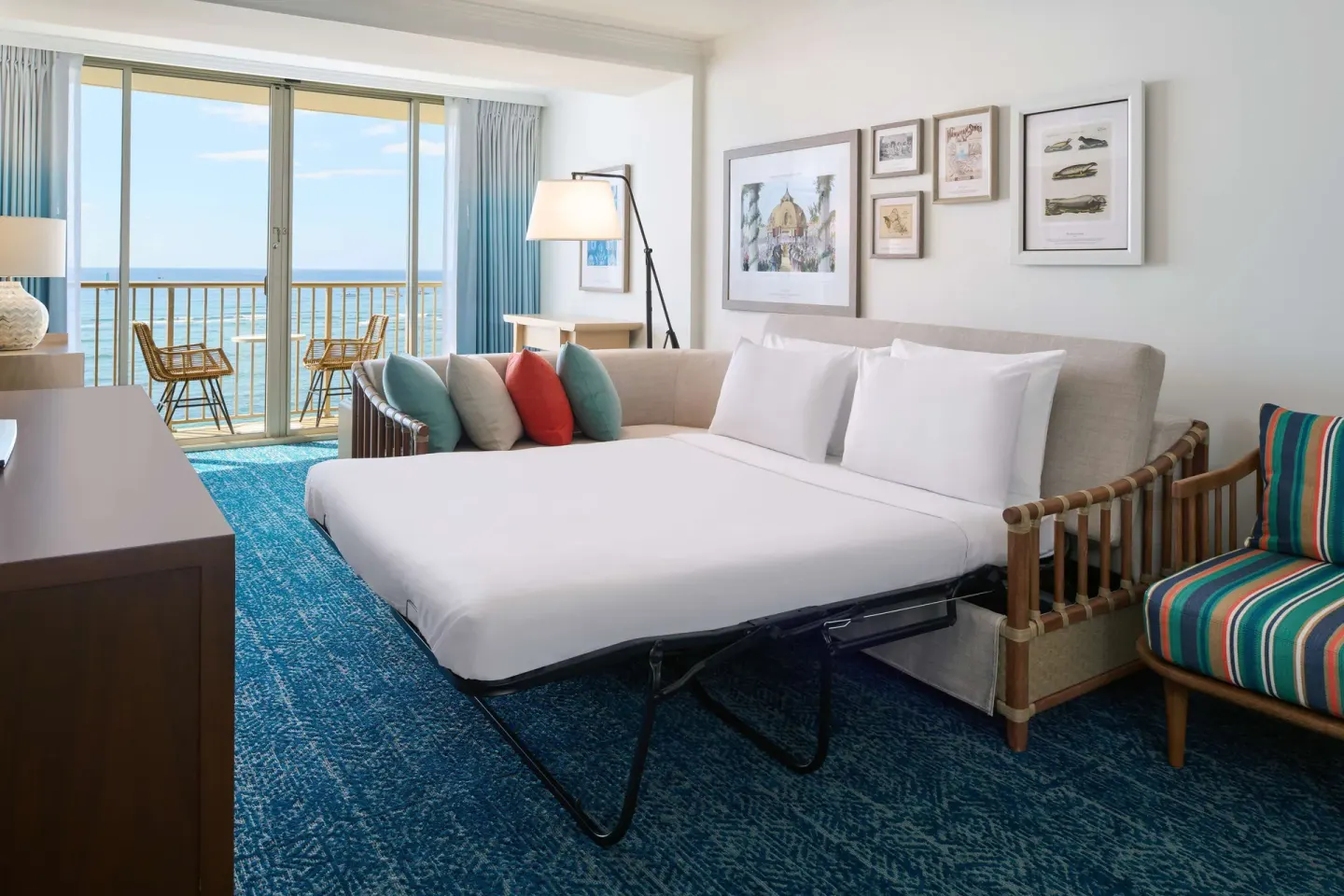 Club Suite sofa bed made up near oceanfront balcony at OUTRIGGER Reef Waikiki Beach Resort.