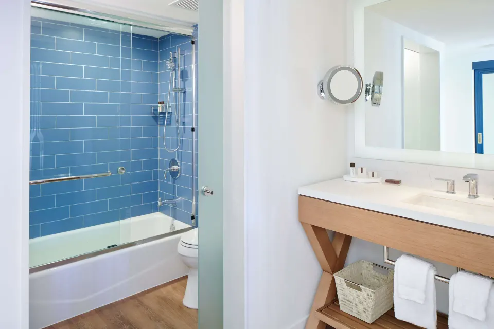 Accessible guest room bathroom vanity and tub shower at OUTRIGGER Reef Waikiki Beach Resort.
