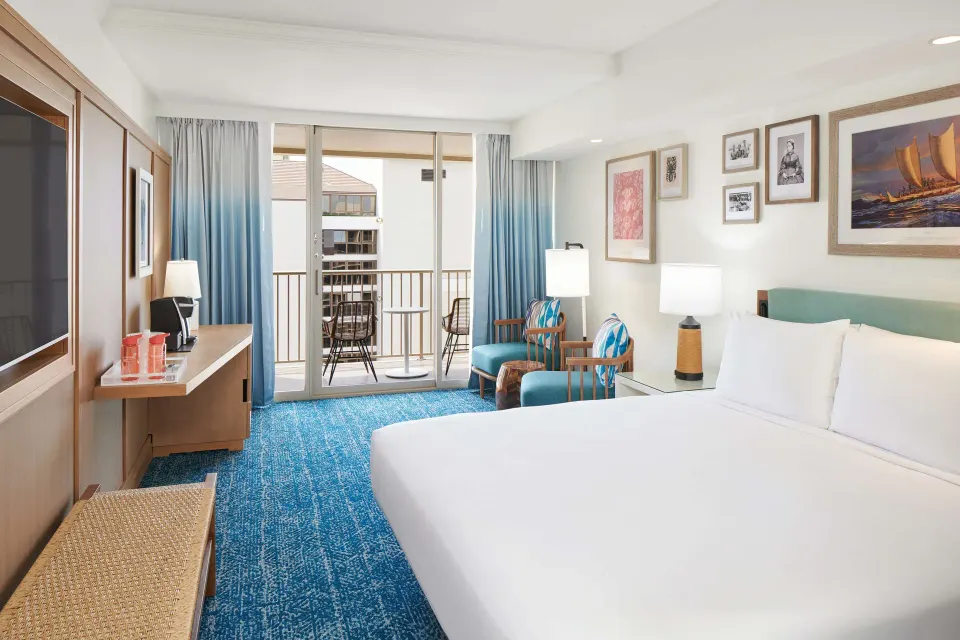 King bed room with balcony seating at OUTRIGGER Reef Waikiki Beach Resort.