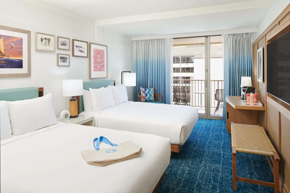 Two-bed guest room with balcony doors at OUTRIGGER Reef Waikiki Beach Resort.