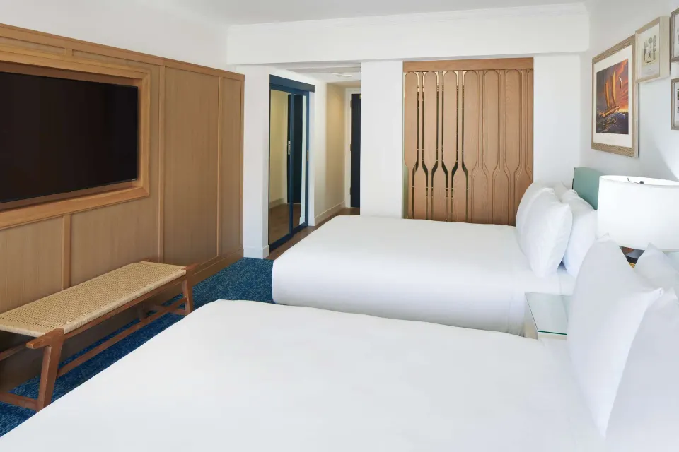 Two-bed guest room with wood wall paneling at OUTRIGGER Reef Waikiki Beach Resort.