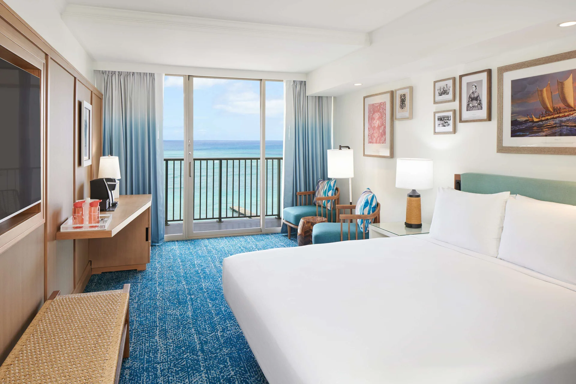Oceanfront king room with desk, chairs, and ocean-facing balcony at OUTRIGGER Reef Waikiki Beach Resort.
