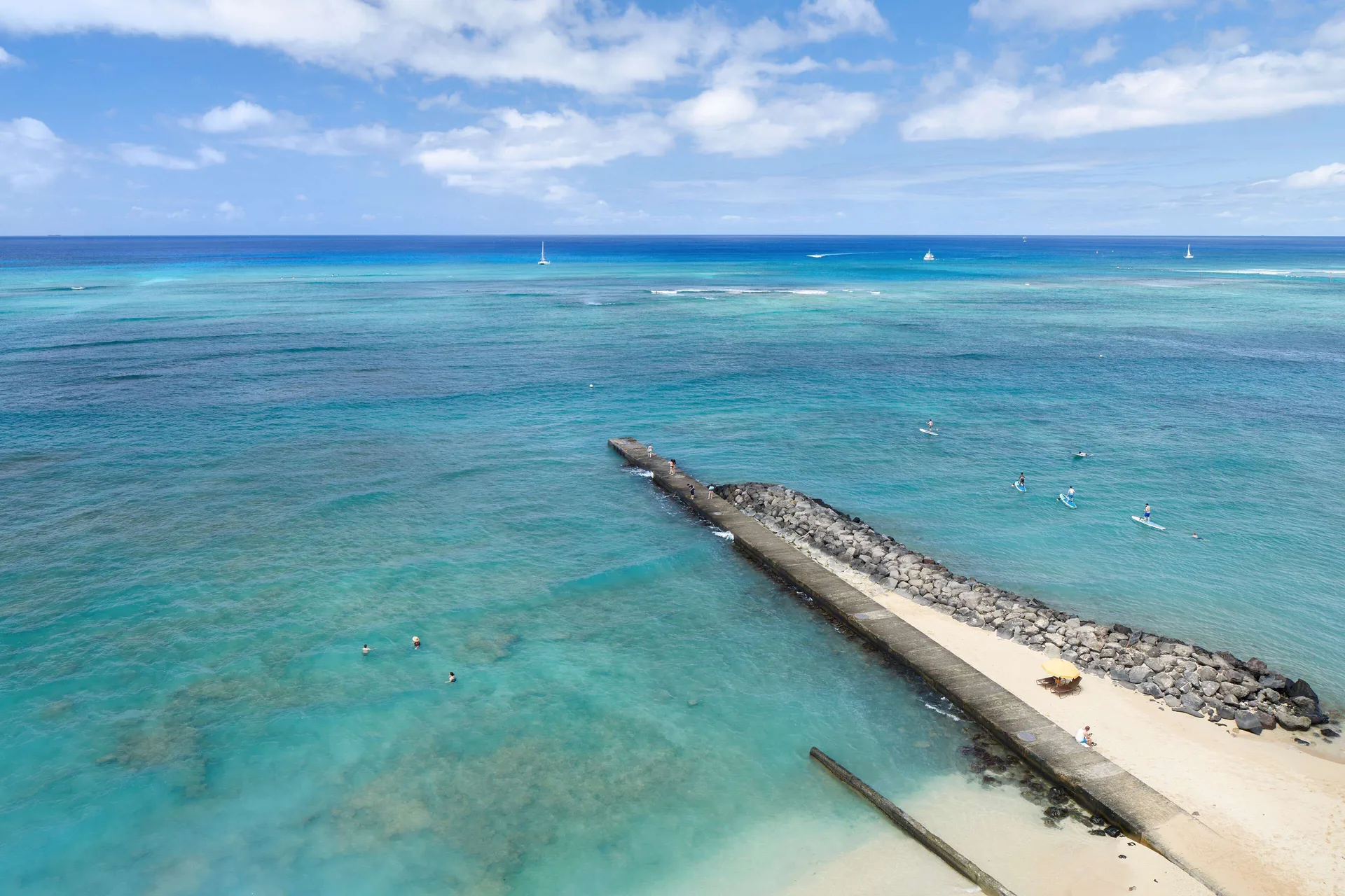 Oceanfront room view of reef, swimmers, and sailboats at OUTRIGGER Reef Waikiki Beach Resort.
