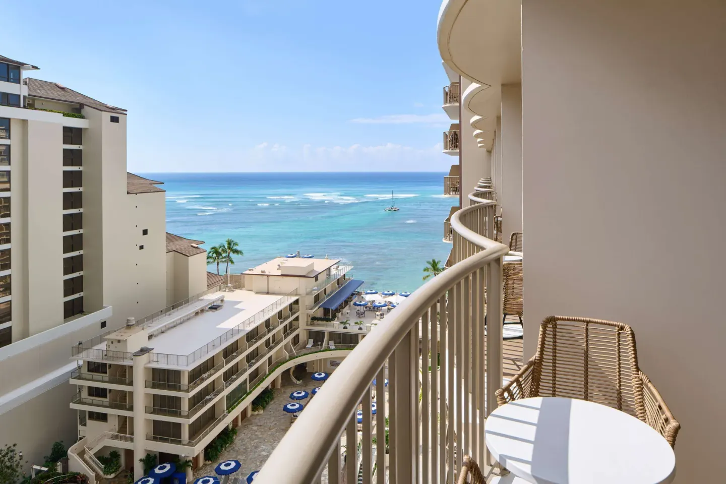 Balcony table and chairs with partial ocean view at OUTRIGGER Reef Waikiki Beach Resort.