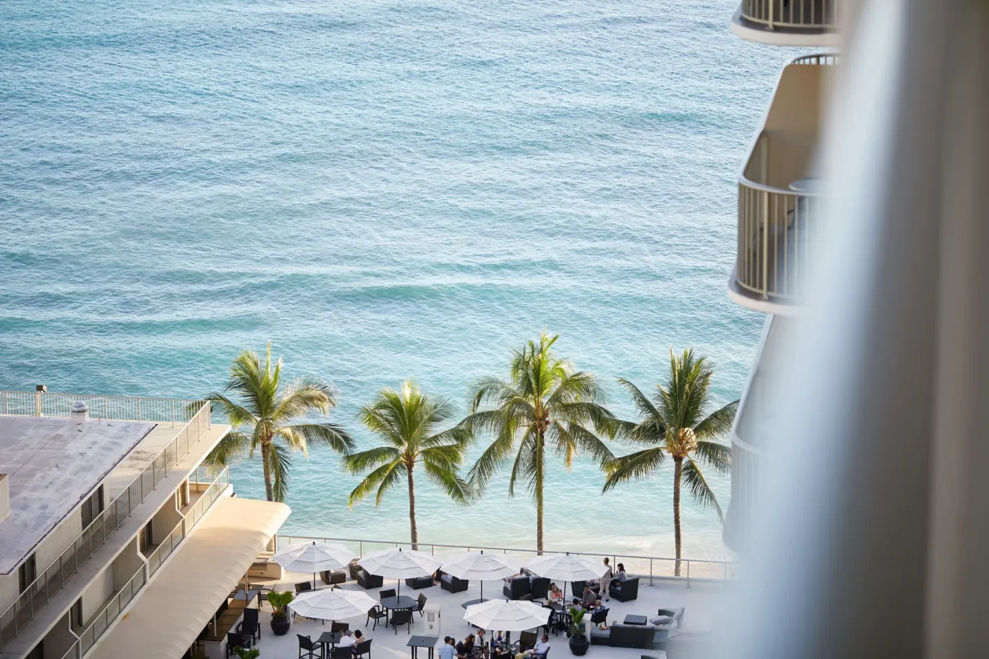 Ocean and palm trees seen from a Partial Ocean View room at OUTRIGGER Reef Waikiki Beach Resort.