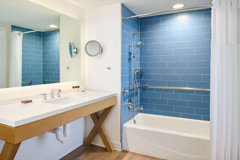 Guest room bathroom with blue tile tub shower at OUTRIGGER Reef Waikiki Beach Resort.