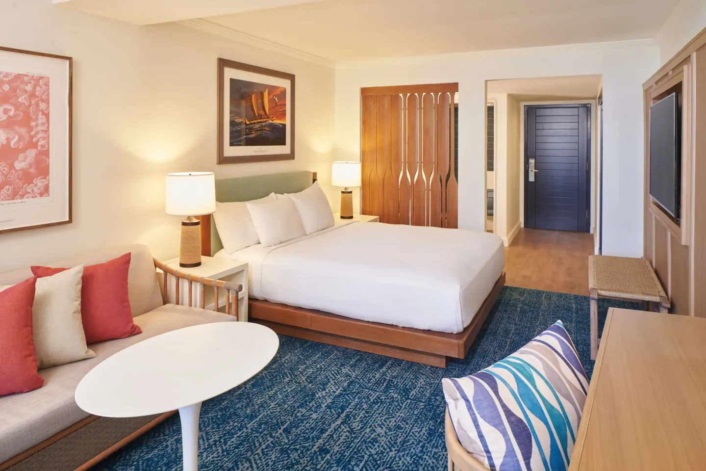 Standard Room king bed with sofa and entry area at OUTRIGGER Reef Waikiki Beach Resort.
