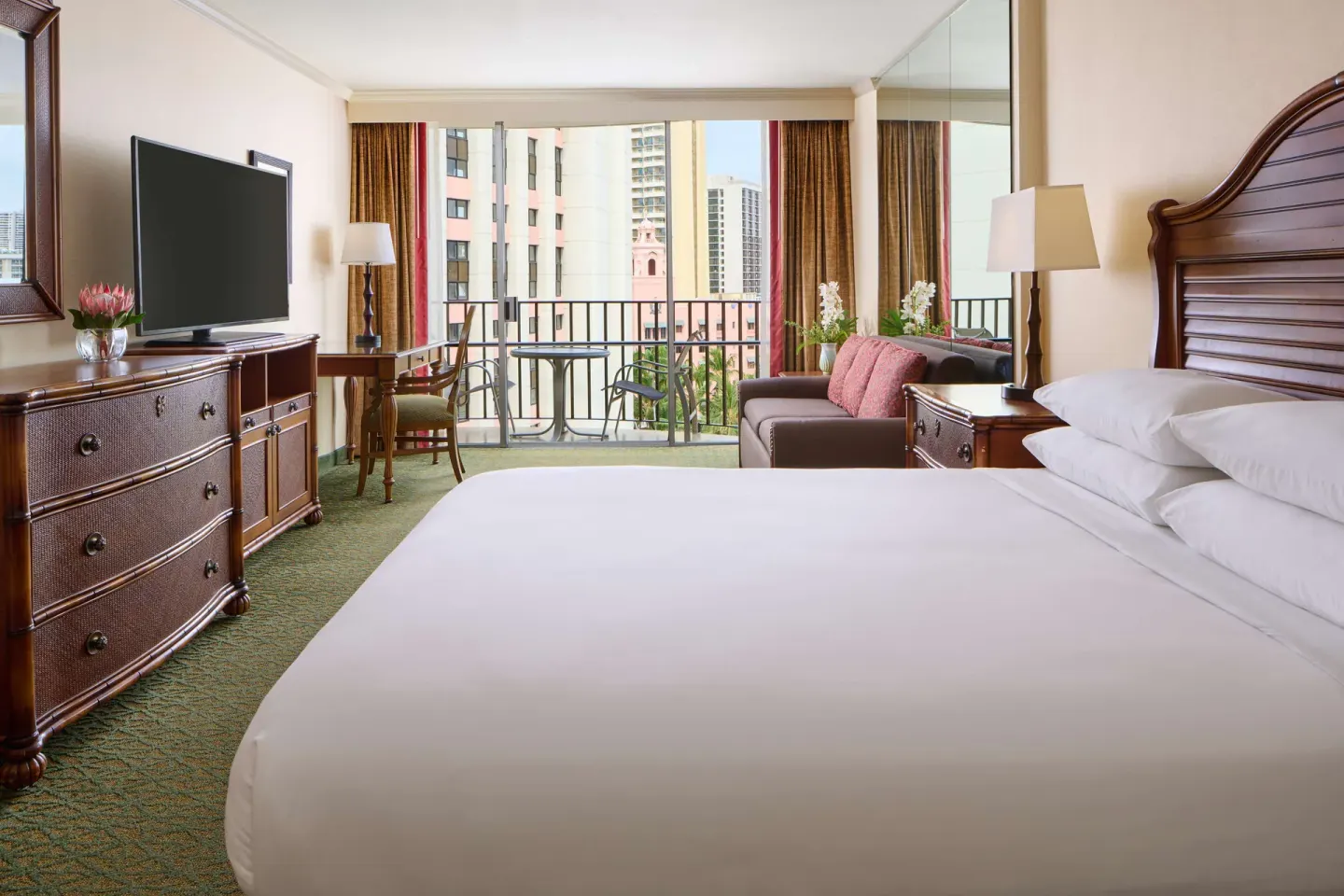 King guest room with city-facing balcony at Outrigger Waikiki Beach Resort.