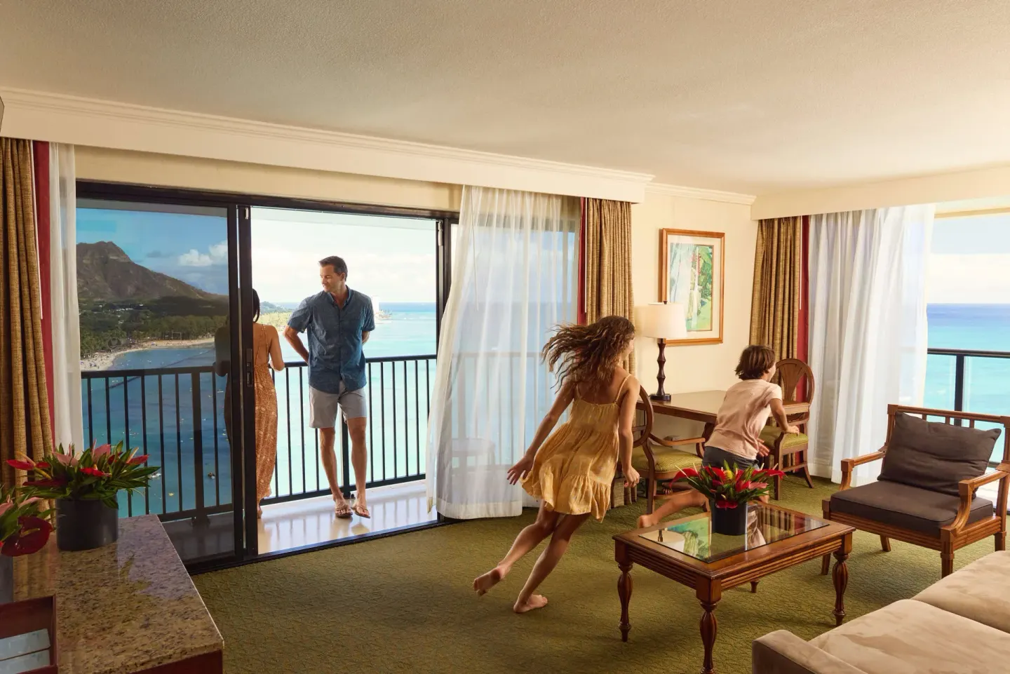 Family in ocean view suite living area at Outrigger Waikiki Beach Resort.