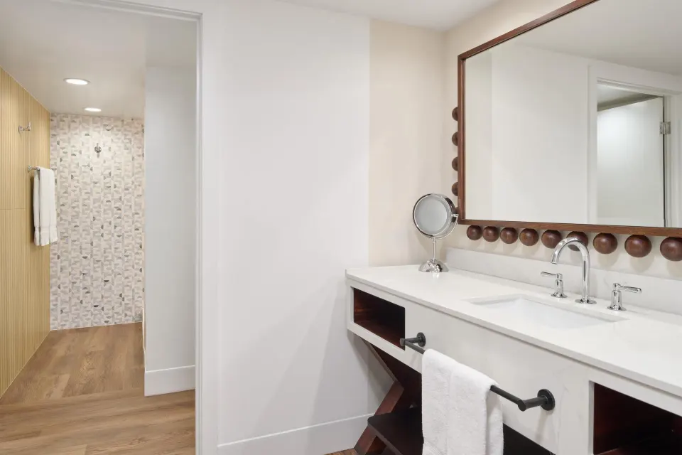 Bathroom vanity in a Club Room 2 Bedrooms Oceanfront at Outrigger Waikiki Beach Resort with walk-in shower.