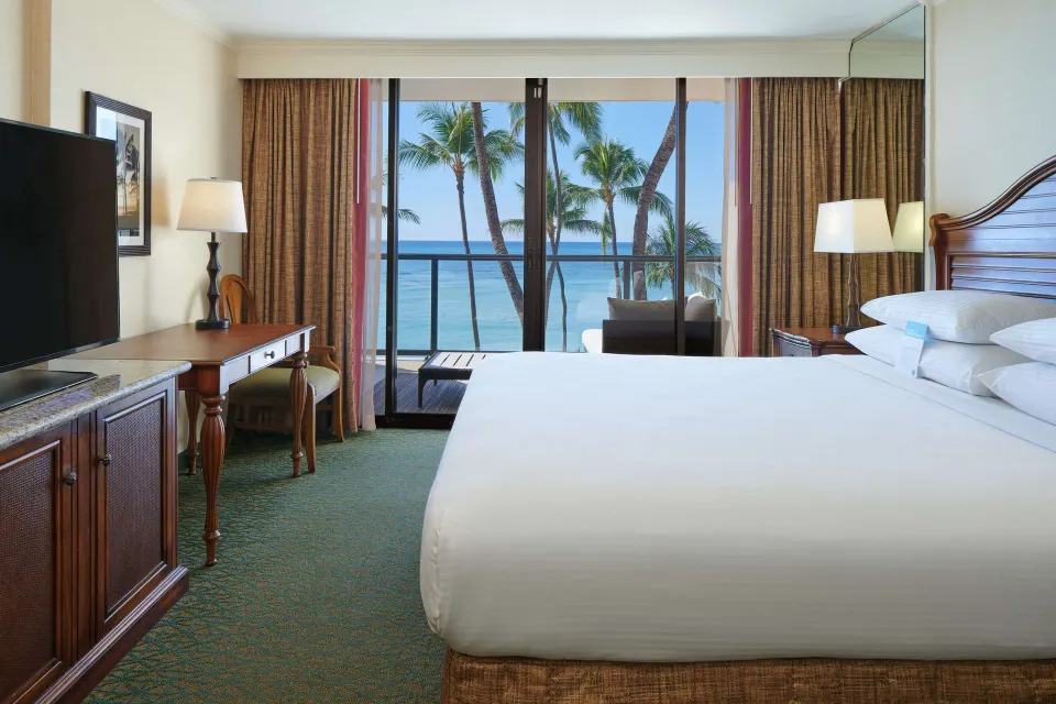 Oceanfront bedroom with king bed and balcony view at Outrigger Waikiki Beach Resort.