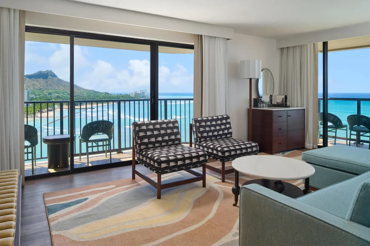 Oceanfront living room in a Club Room 2 Bedrooms at Outrigger Waikiki Beach Resort with balcony views.