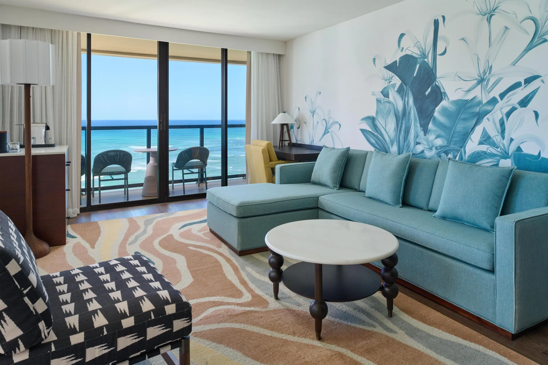 Club Room 2 Bedrooms Oceanfront lounge at Outrigger Waikiki Beach Resort with blue sofa and balcony.