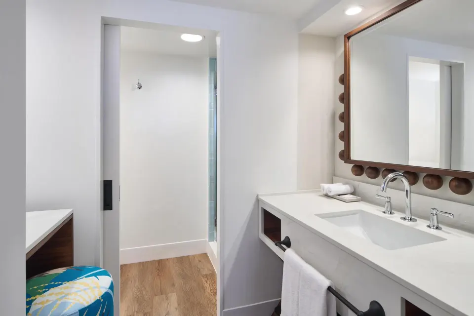 Bathroom sink and shower entry in a Club Room at Outrigger Waikiki Beach Resort.