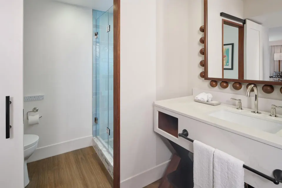 Bathroom vanity and glass shower in a Club Room at Outrigger Waikiki Beach Resort.
