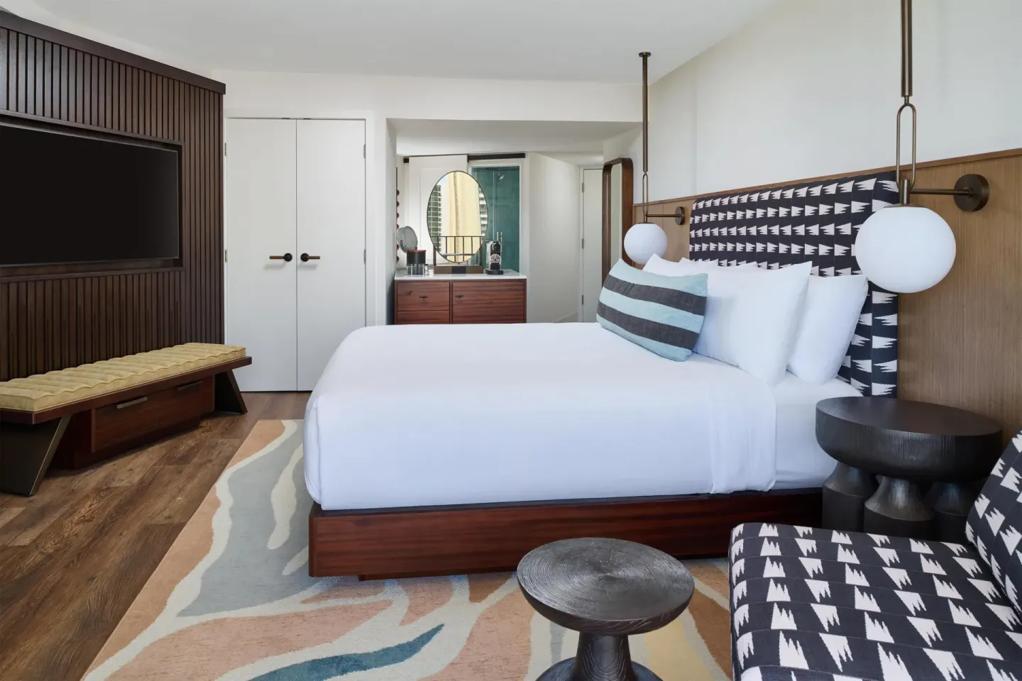 King bed, TV wall, and vanity area in a Club Room at Outrigger Waikiki Beach Resort.