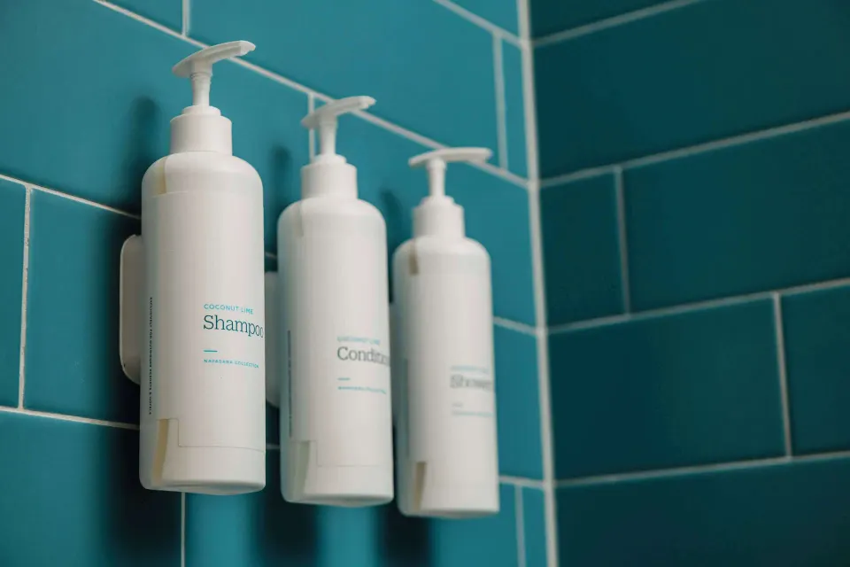 Shower amenity dispensers on blue tile at Outrigger Waikiki Beach Resort.