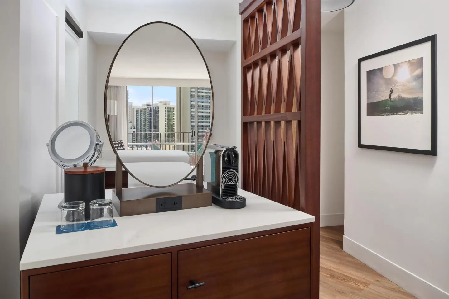 Vanity area with round mirror in a Club Room at Outrigger Waikiki Beach Resort.