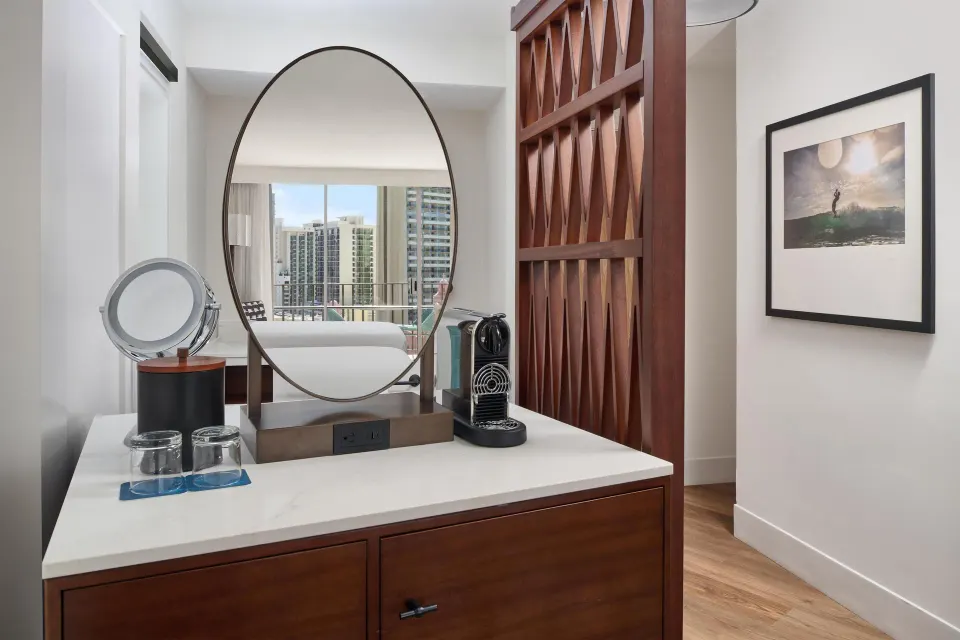 Vanity area with round mirror in a Club Room at Outrigger Waikiki Beach Resort.