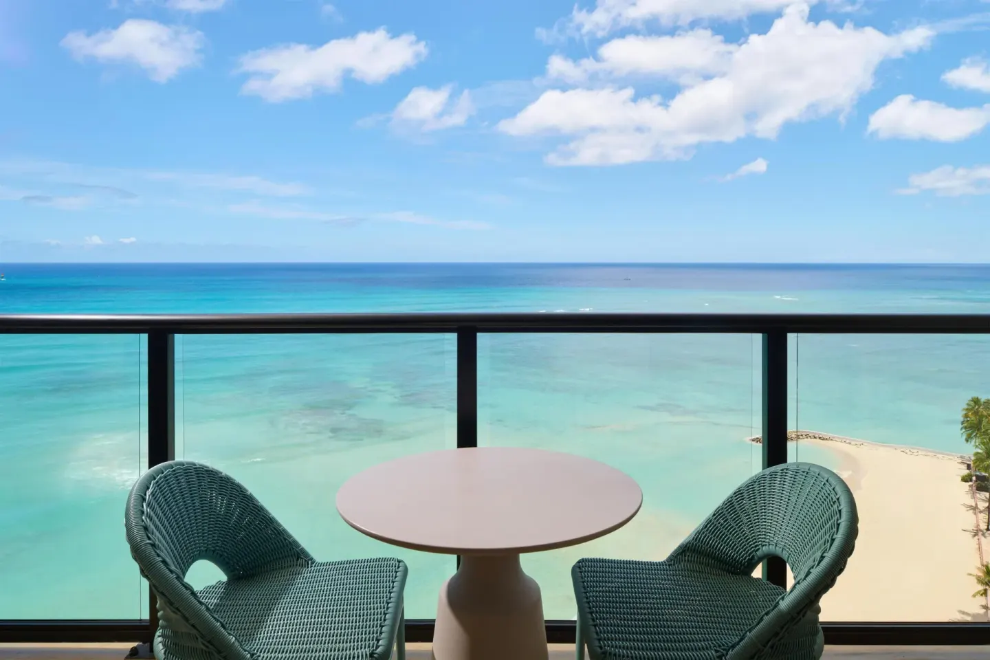 Oceanfront balcony with chairs and turquoise water at Outrigger Waikiki Beach Resort.