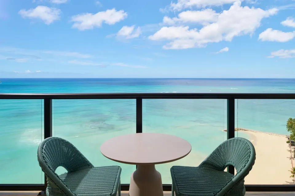 Oceanfront balcony with chairs and turquoise water at Outrigger Waikiki Beach Resort.