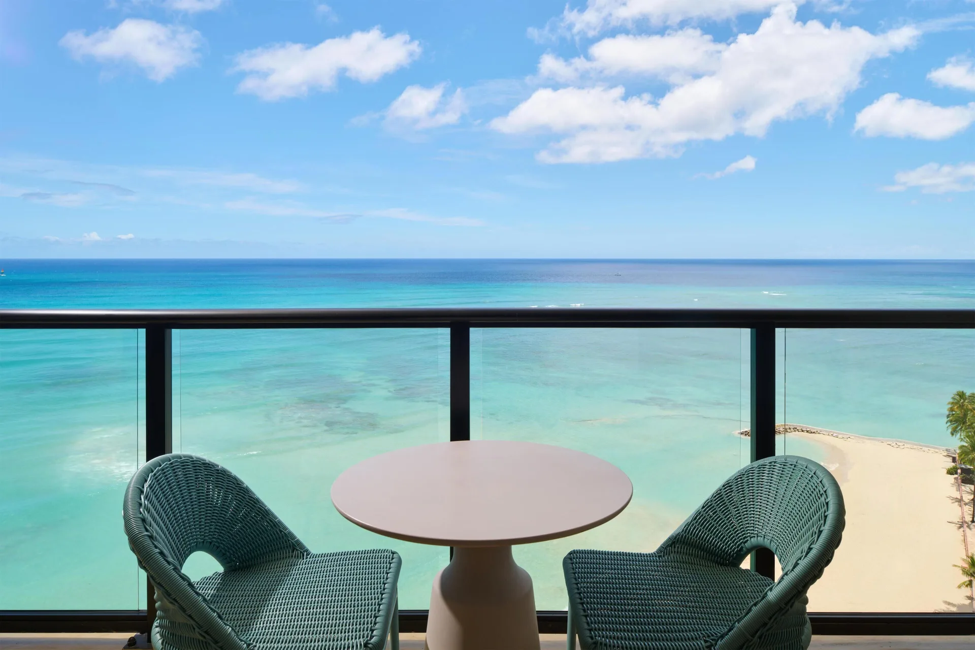 Oceanfront balcony with chairs and turquoise water at Outrigger Waikiki Beach Resort.