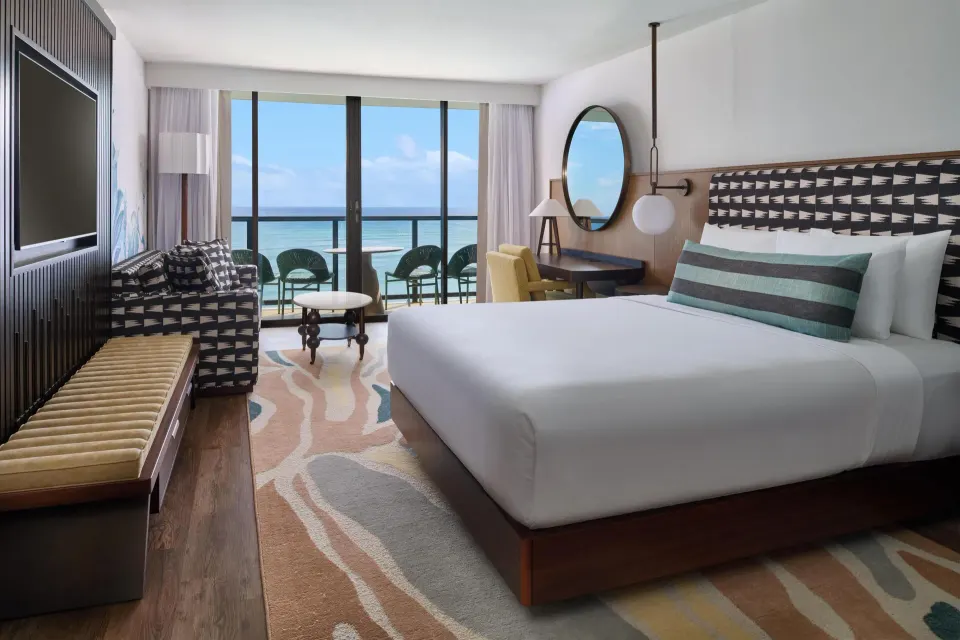 Club Room Oceanfront king bed and balcony view at Outrigger Waikiki Beach Resort.