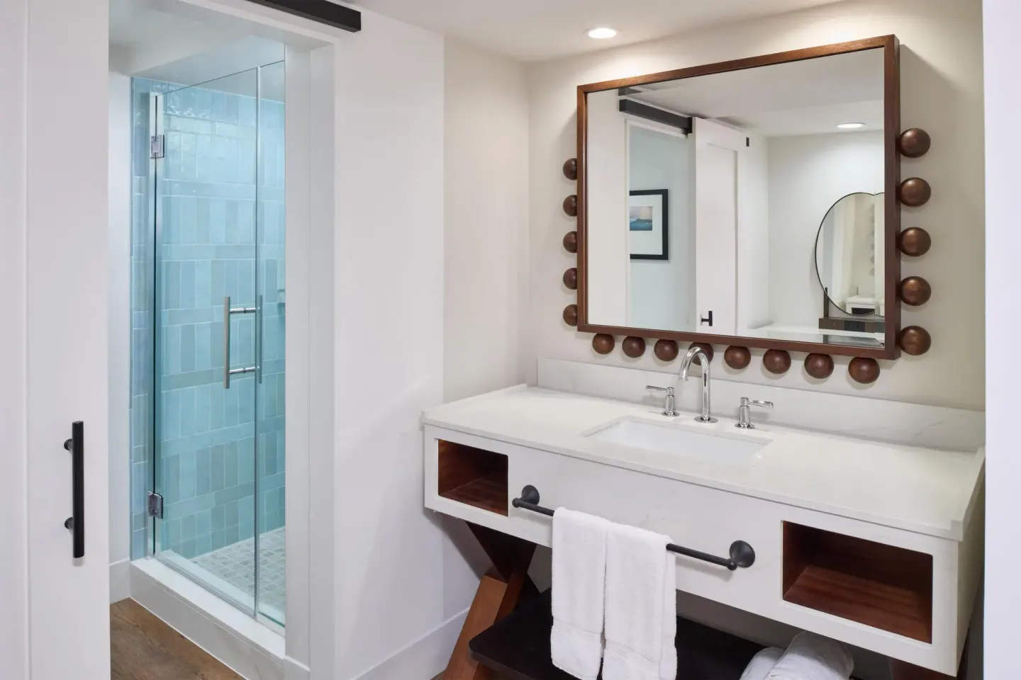 Oceanfront room bathroom with white vanity and glass shower at Outrigger Waikiki Beach Resort.