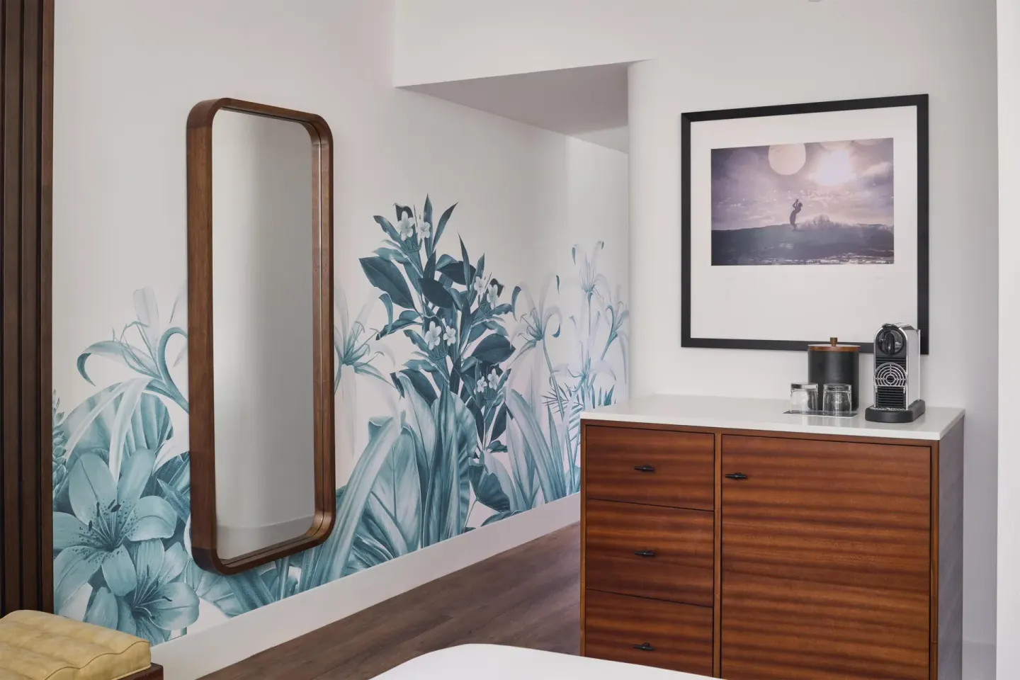 Oceanfront room entry area with mirror, floral wall art, and dresser at Outrigger Waikiki Beach Resort.
