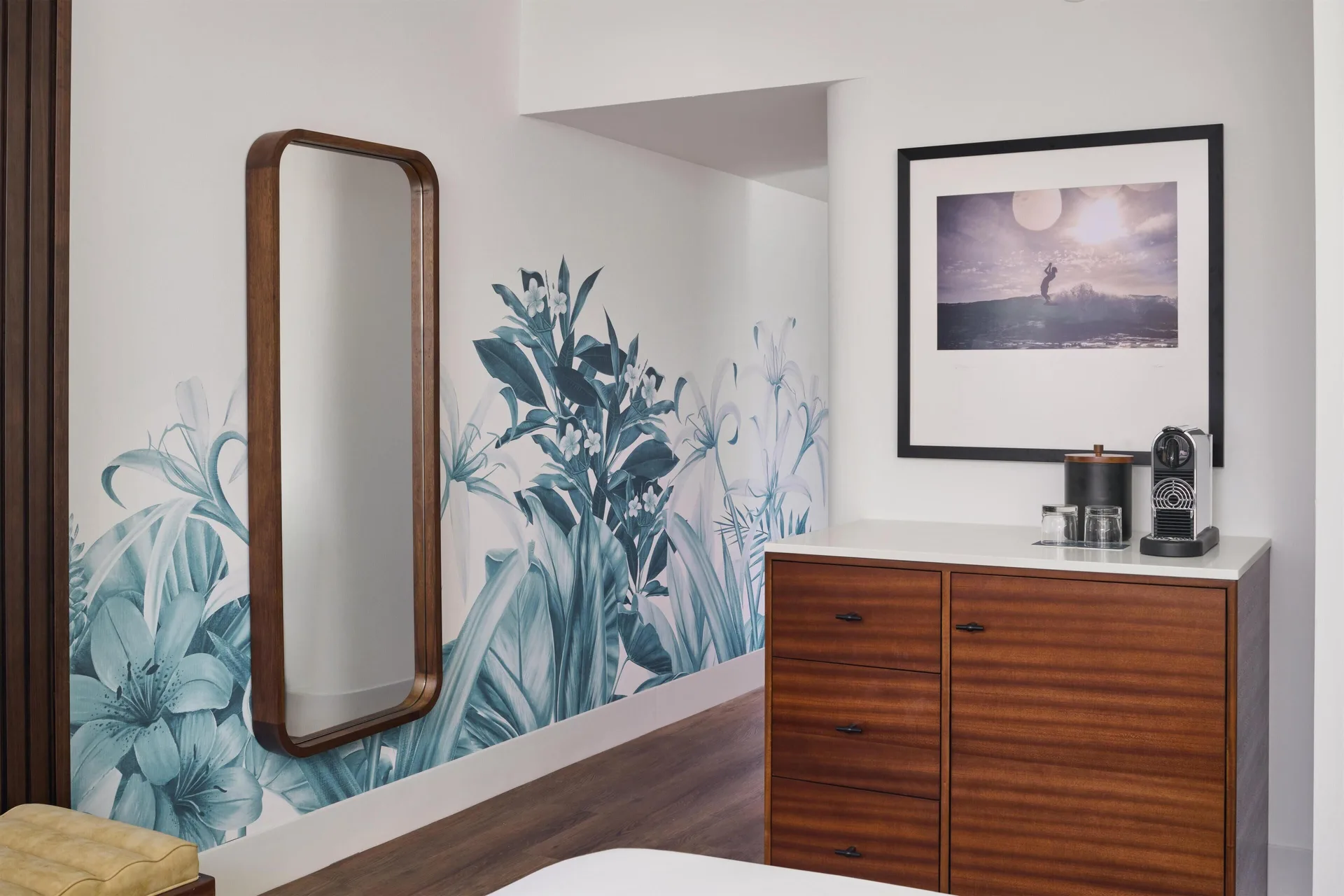 Oceanfront room entry area with mirror, floral wall art, and dresser at Outrigger Waikiki Beach Resort.