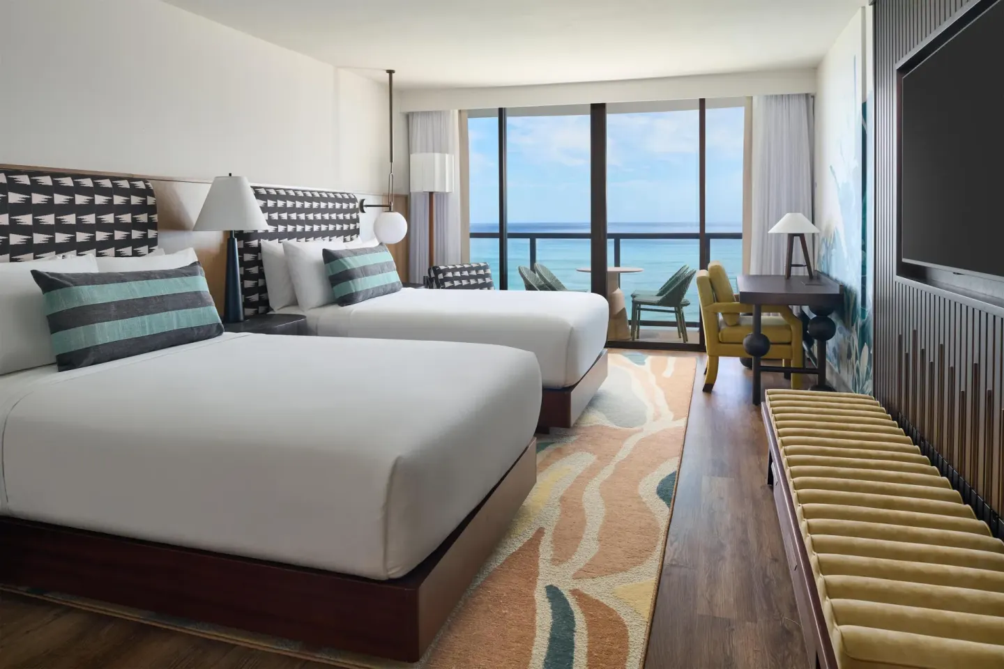 Oceanfront room with two beds, seating, and ocean view at Outrigger Waikiki Beach Resort.