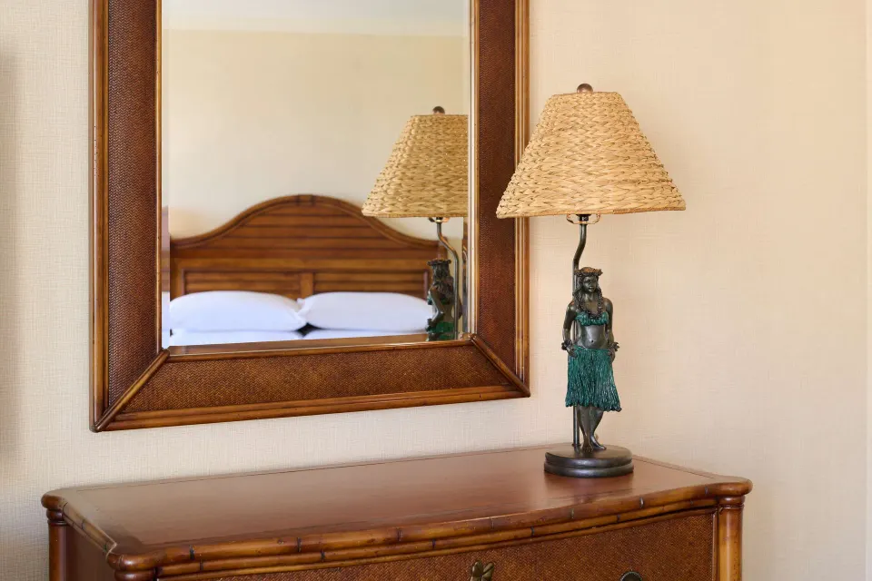 Dresser, mirror, and hula-style lamp in a Partial Ocean View room at Outrigger Waikiki Beach Resort.