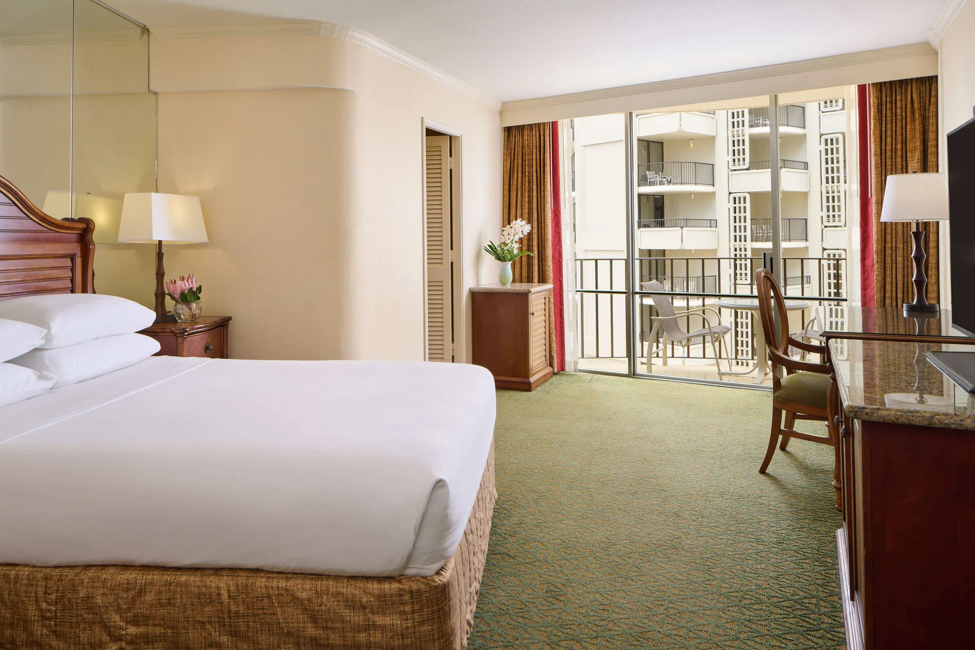 Partial Ocean View guest room with king bed and balcony at Outrigger Waikiki Beach Resort.