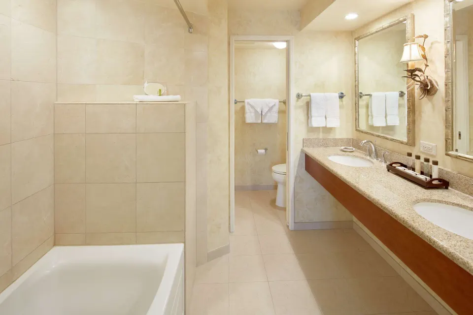 Suite bathroom with double vanity and separate toilet area at Outrigger Waikiki Beach Resort.