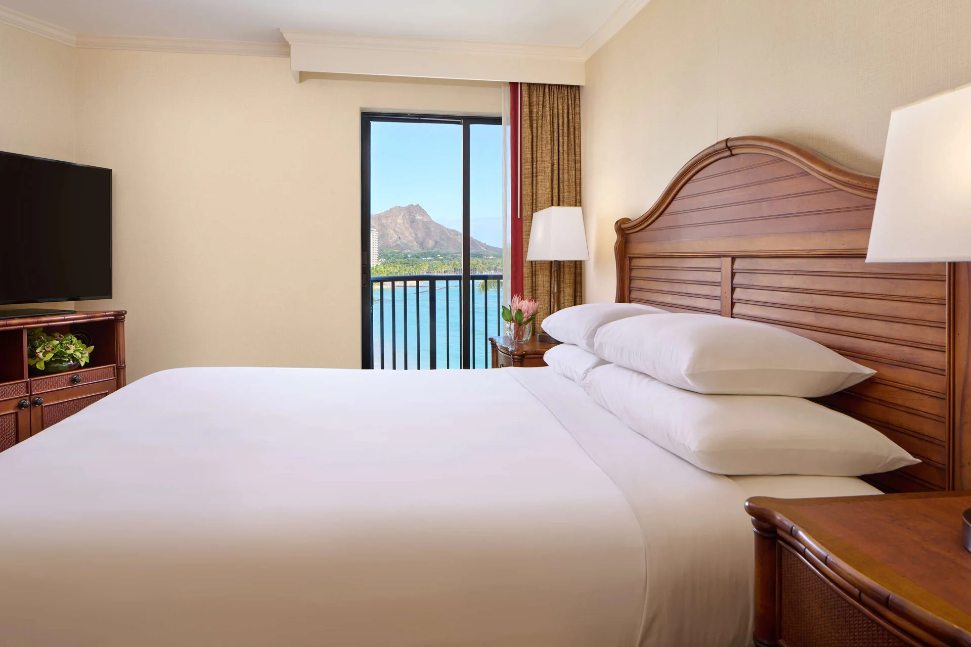 Oceanfront suite bedroom with king bed and Diamond Head view at Outrigger Waikiki Beach Resort.