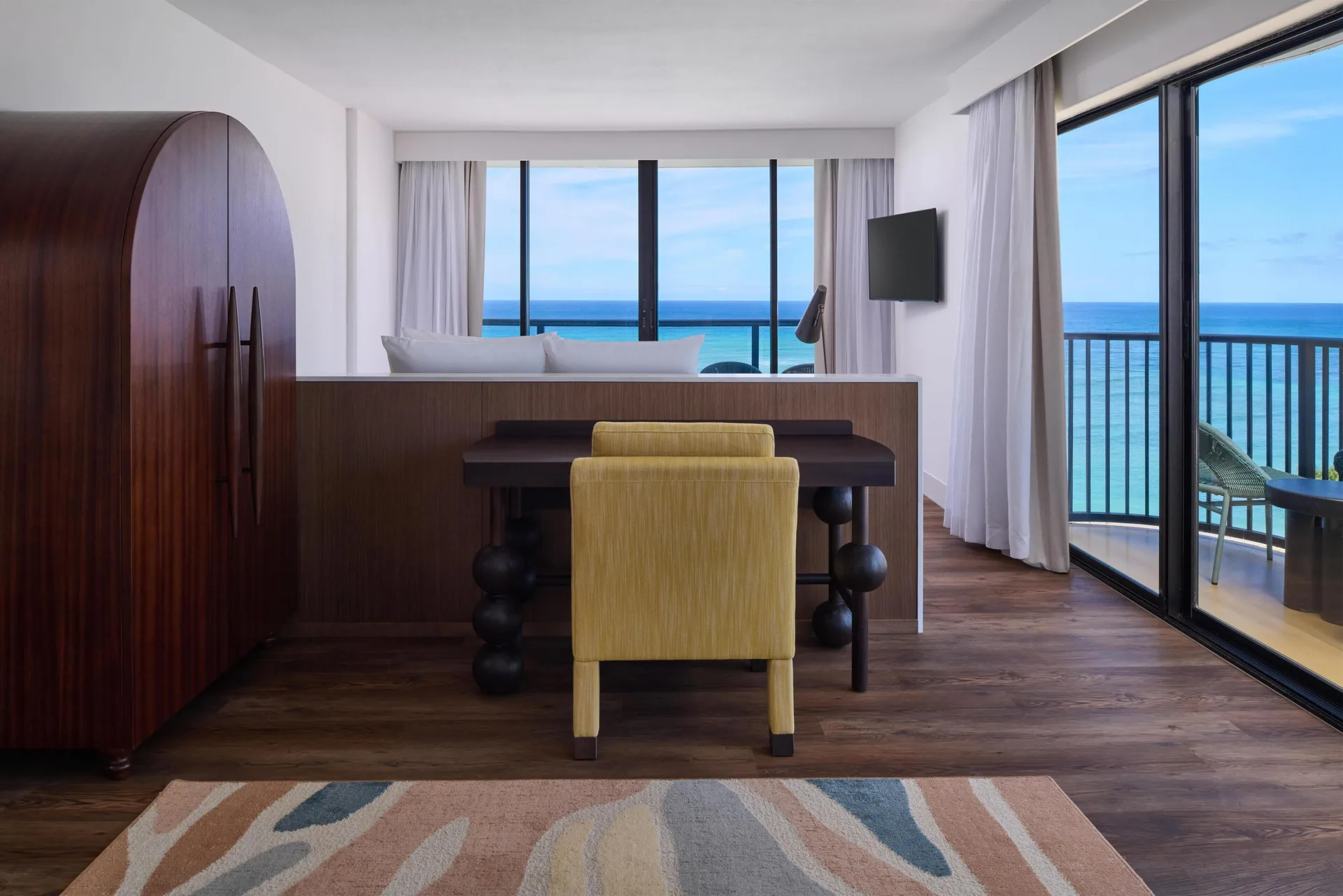 Suite desk and ocean-facing bedroom at Outrigger Waikiki Beach Resort.