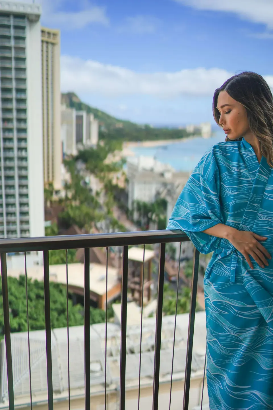 Guest in a robe on a balcony overlooking Waikiki at OUTRIGGER Waikiki Beachcomber Hotel.