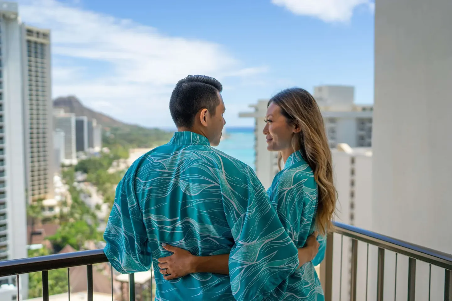Couple on a balcony with Waikiki and ocean views at OUTRIGGER Waikiki Beachcomber Hotel.