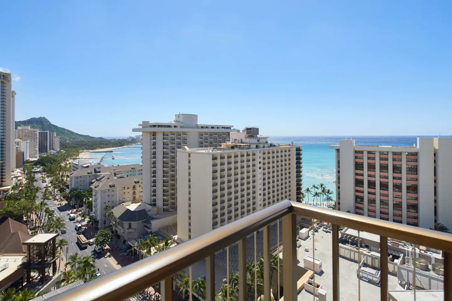 Corner balcony view of Waikiki buildings, beach, and ocean at OUTRIGGER Waikiki Beachcomber Hotel.