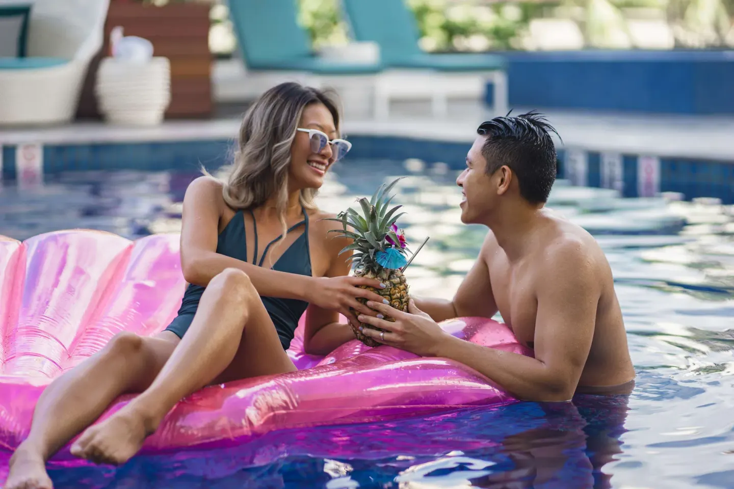 Couple relaxing in the pool with a pineapple drink at OUTRIGGER Waikiki Beachcomber Hotel.