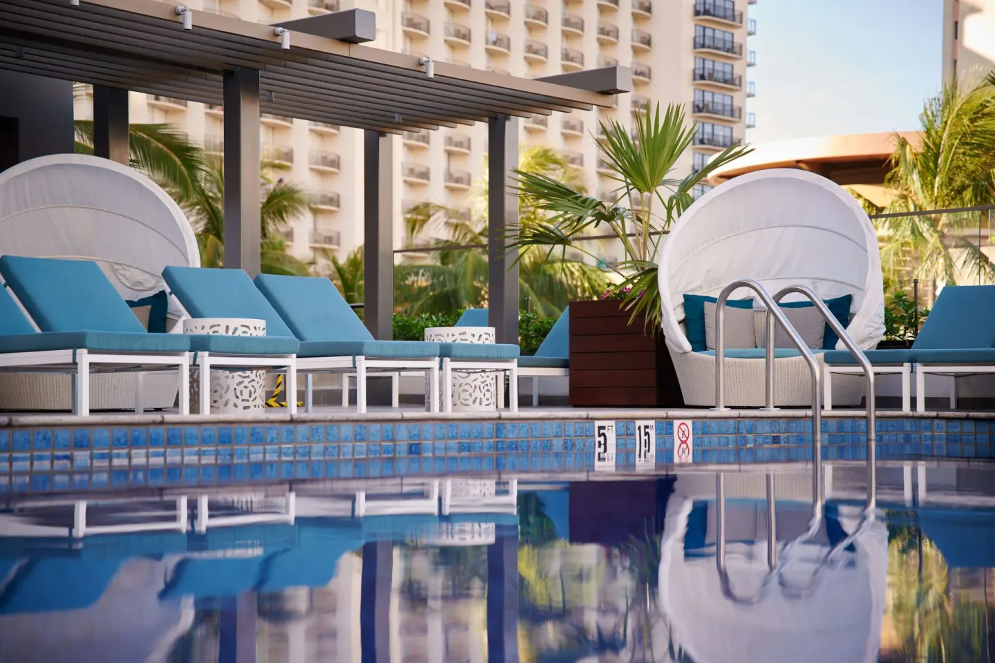 Close-up of cabanas and loungers by the pool at OUTRIGGER Waikiki Beachcomber Hotel.
