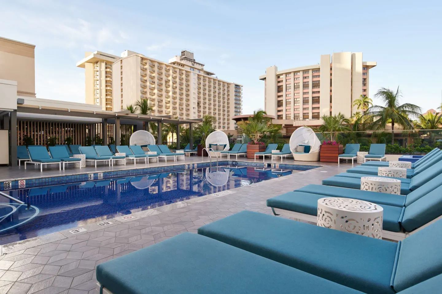 Poolside lounge chairs and cabanas at OUTRIGGER Waikiki Beachcomber Hotel.