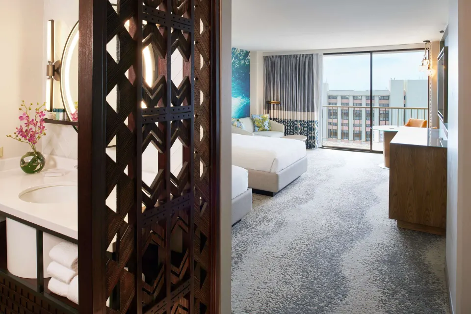 Junior Suite entry with vanity, carved screen and balcony-facing room at OUTRIGGER Waikiki Beachcomber Hotel.