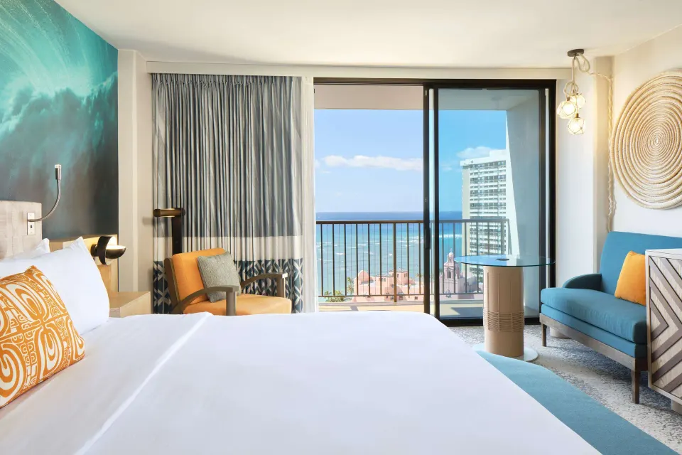 King bed room seating area and ocean balcony at OUTRIGGER Waikiki Beachcomber Hotel.
